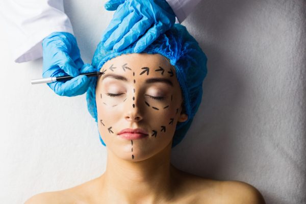 Peaceful young patient with dotted lines on the face in an examination room